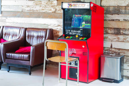 BANGKOK, THAILAND - OCTOBER 19: retro red game coin console or Vintage arcade machine at wooden wall...