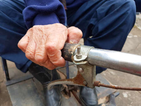 close-up hand of disabled old man holding tricycle handleの写真素材
