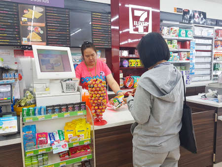 CHIANG RAI, THAILAND - NOVEMBER 6 : Unidentified asian woman waiting to pay at the cashier counter at a 7-Eleven convenience store on November 6, 2017 in Chiang rai, Thailand.のeditorial素材