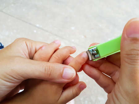 close-up mother cutting fingernails for her babyの写真素材