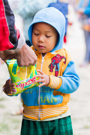 CHIANG RAI, THAILAND - JANUARY 13 : Unidentified boy eating snacks from a hand of his father on January 13, 2018 in Chiang rai, Thailand.のeditorial素材