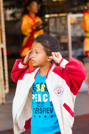 NAKHON SAWAN, THAILAND - FEBRUARY 8 : unidentified asian girl closing her ears at parade in Chinese New Year festival on February 8, 2019 in  Nakhon Sawan, Thailand.のeditorial素材