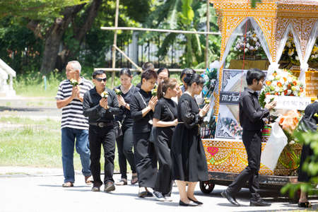 CHIANG MAI, THAILAND - MAY 19: Unidentified sad people in black cloths walking around the wooden palace of the dead body Thai traditional cremating ritual in countryside on May 19, 2018 in Chiang Mai, Thailand.のeditorial素材