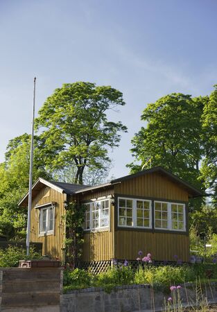 Idyllic yellow cottage in botanical gardenの写真素材