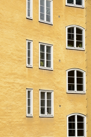 Close up of a apartment building. White windows on a yellow facadeの写真素材