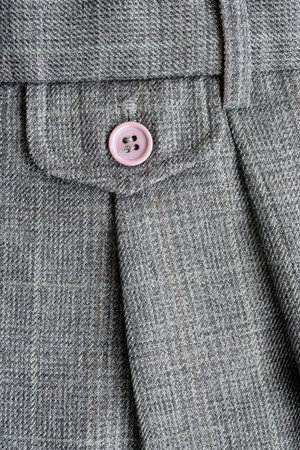 Detail on the rear pocket of grey wool trousers