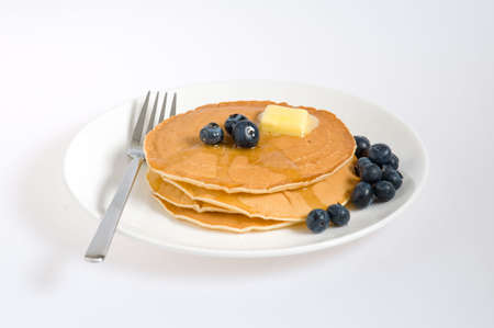 blueberry pancakes on a plate with fork isolated on white の写真素材