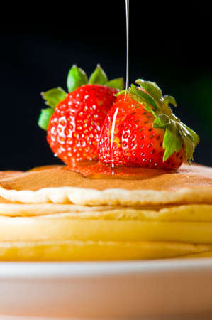 Strawberry butter pancake with honey/ maple sirup flowing down closeup shootの写真素材