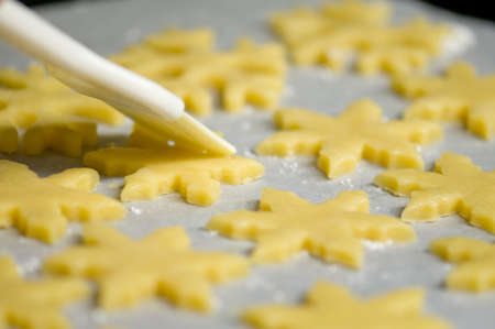 glazing christmas cookies before backing with eggの写真素材