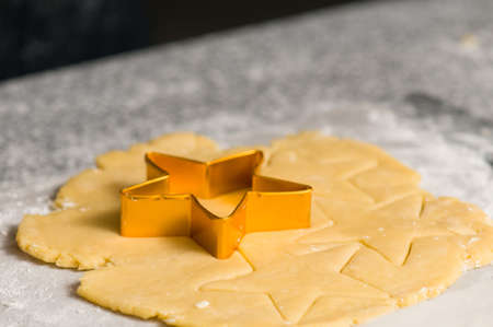 Star shape cookie cutter on dough pre cutted doughの写真素材