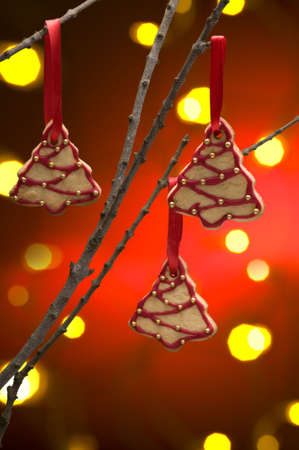 Christmas cookies as tree decoration with a red gold back froundの写真素材