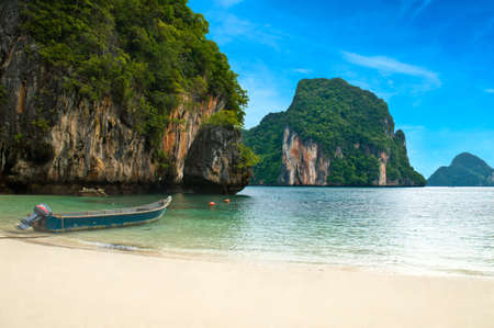A long tail boat by the beach in Thailand green mountainsの写真素材
