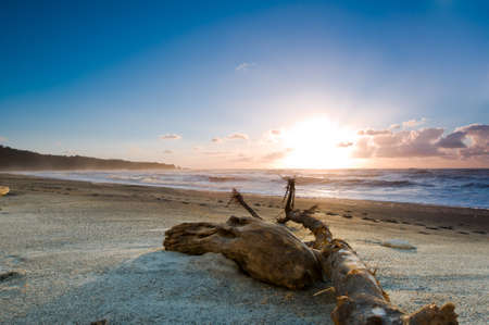 Sunset over a misty beach with burning skyの写真素材