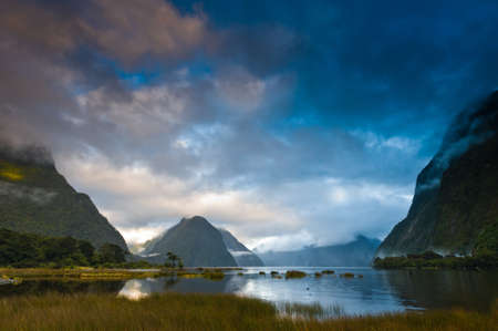 Cloudy morning at milford sound with sunrise in the back groundの写真素材