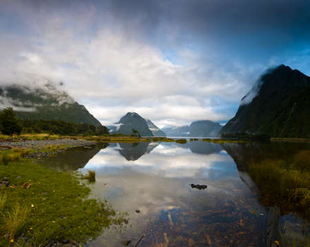 Cloudy morning at milford sound with sunrise in the back groundの写真素材