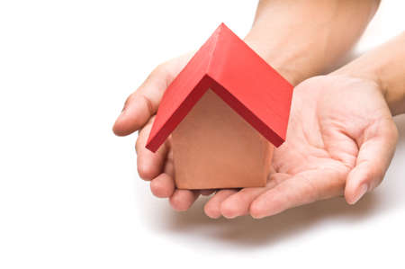 red roofed house over white in human handの写真素材