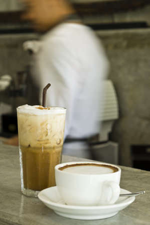 Iced cafÃ© late and cappuccino on a bar counter, shallow depth of field の写真素材