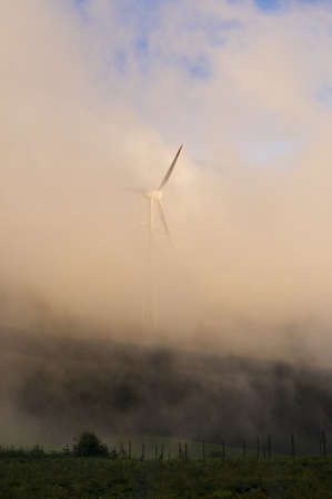 Windmill in the countryside during fog in the eveningの写真素材