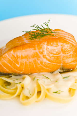 Salmon steak on pasta, decorated with dill close-upの写真素材