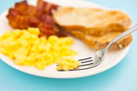 American breakfast, bacon and scrambled egg, fork lifts eggの写真素材