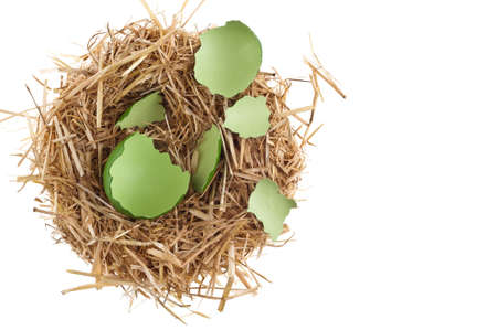 Straw nest with broken eggshell over white studio shootの写真素材