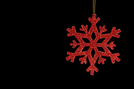 Red snow flake on a black background for Christmasの写真素材