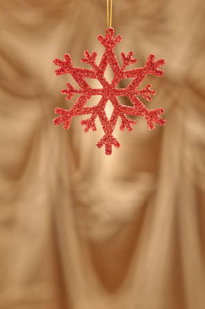 Red snow flake on a gold background for Christmasの写真素材