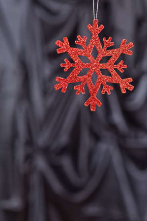 Red snow flake on a black background for Christmasの写真素材