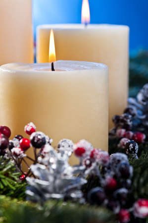 Three burning candles in an advent flower arrangement for advent and Christmas a nice close up shootの写真素材