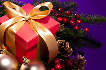 Red artificial snow flake in a christmas tree in front of a reflecting color background
