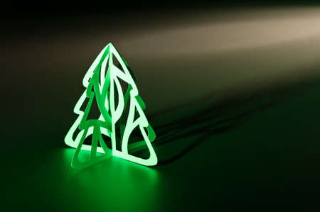 Paper cut Christmas tree illuminated with long shadowの写真素材
