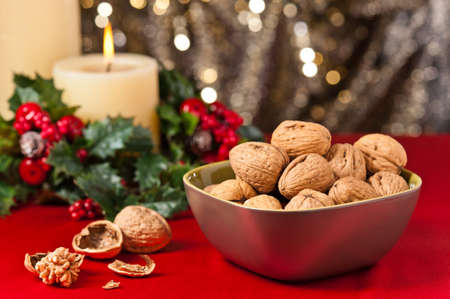 Bowl of walnuts in festive setting in front of a gold glitter backgroundの写真素材