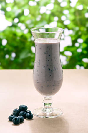 Blueberry milk shake with real fruit and a green backgroundの写真素材