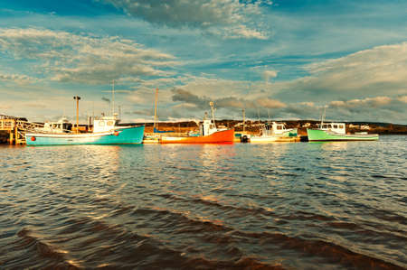 Fishing boat during sunset in the harbour with dramatic skyの写真素材