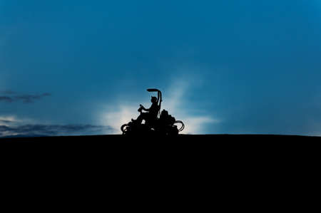Silhouette of a lawn mower in the early morningの写真素材