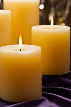 Four candles over purple velvet, with gold glitter backgroundの写真素材