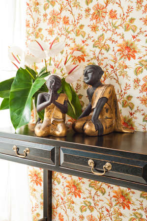 Side table with flowers and interior decoration next to bright windowの写真素材