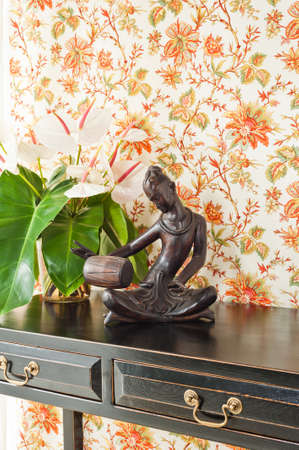 Side table with flowers and interior decoration next to bright windowの写真素材