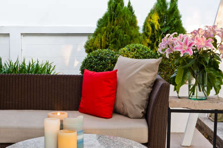 Outdoor patio seating area with nice Rattan sofa at sunset Outdoor patio seating area with nice Rattan sofa at sunset
