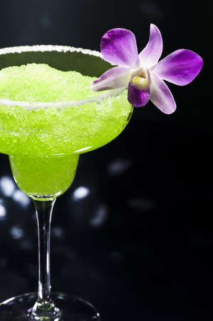 Green margarita cocktail in front of disco lightsの写真素材