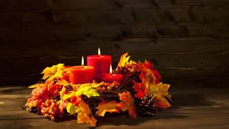 Candles in nice and beautiful colorful autumn leavesの写真素材