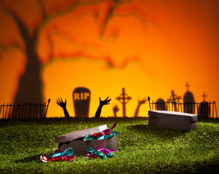 Halloween coffin on lawn with sweets and candiesの写真素材