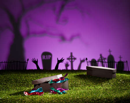 Halloween coffin on lawn with sweets and candiesの写真素材
