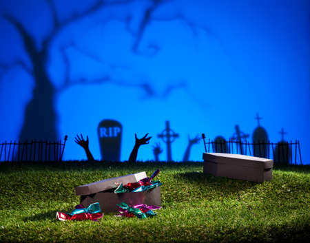 Halloween coffin on lawn with sweets and candiesの写真素材