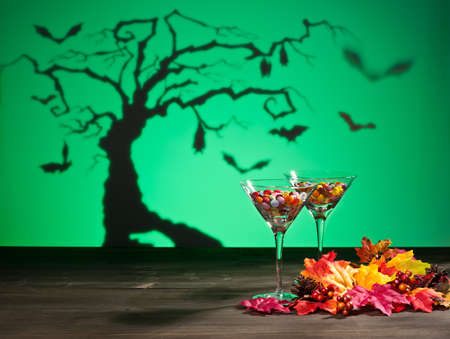 Halloween landscape a tree and a Martini glass with sweetsの写真素材