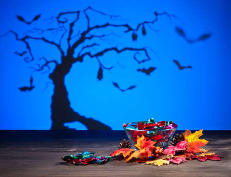 Halloween tree bats sweets and golden leafs の写真素材