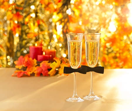 Champagne glasses with conceptual same sex decoration for gay men in front of autumn decoの写真素材