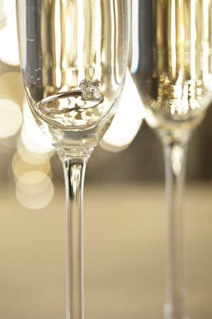 Champagne glasses with engagement Jewelry in front of autumn backgroundの写真素材