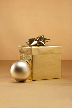 Gold bauble and present in Christmas settingの写真素材