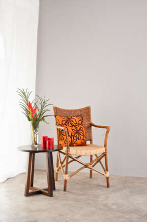 Rattan chair with orange colored pillow in a bright setting
の写真素材